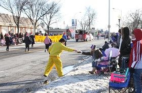 二零零八年十二月七日，密西根州罗彻斯特（Rochester）举行第五十七届圣诞大游行。法轮功作为唯一的亚裔团体，再次应邀参加。图为观众不畏严寒，接过法轮功