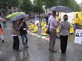 民众冒雨观看法轮功学员的功法演示