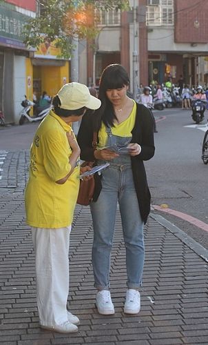 图15：慈悲善良的法轮功学员热心地向路人传递真相与祝福。