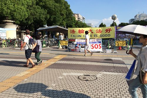 在爱知县名古屋市的荣（Sakae）设立的真相点，法轮功学员们打出了写有“法轮大法好”、“法轮功已弘传世界100多个国家与地区”的真相横幅。