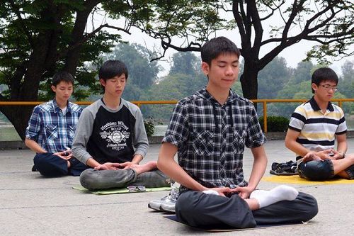 图1. 暨南国际大学学生余以澄（前一）在清华大学校园，和清大“法轮大法社”的同修一起炼功。