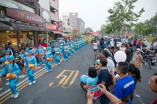 '图5：活泼喜气的腰鼓队吸引很多民众用手机拍照留念。'