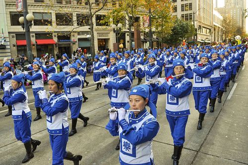 '图3-4：由上百位法轮功学员组成的、穿着传统服装的天国乐团成为游行的亮点，给两旁观众带来清新和惊喜。'