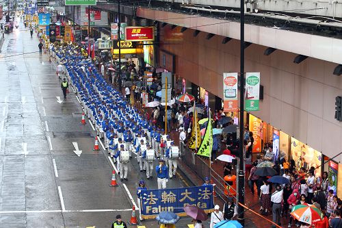 图1-3：天国乐团引领法轮功学员队伍，游行从港岛区英皇道、轩尼诗道，途经闹市铜锣湾、湾仔、中环，最终到西环中联办，历时三个多小时，沿途吸引港民及中西旅客观看。