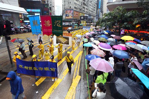 图6-12：法轮功学员希望民众了解真相，在游行队伍中打出了揭迫害、唤良知、启善念、劝三退等横幅。