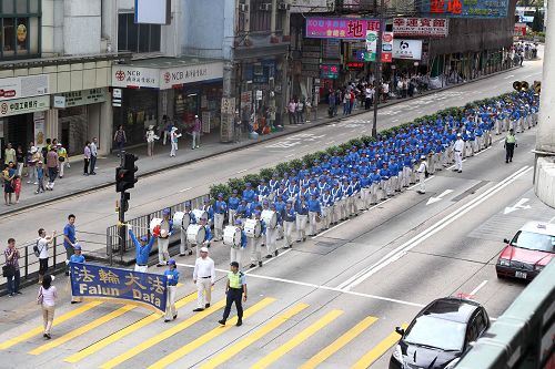 图6-8：法轮功学员的游行队伍由天国乐团前导，吸引道路两侧的广大民众驻足围观及拍照。