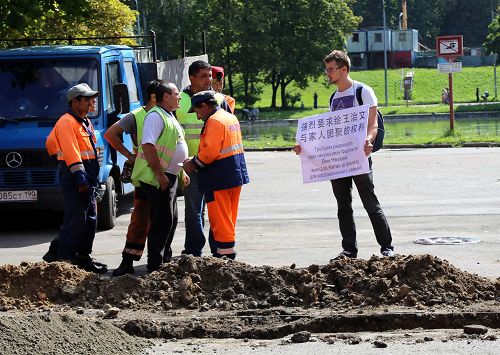 图：莫斯科法轮功学员在中领馆前举办单人接力抗议活动，声援王治文。