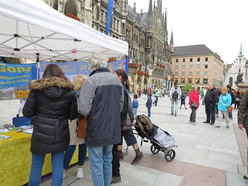 '图1～6：二零一七年九月二日，法轮功学员在德国慕尼黑的玛琳广场（Marienplatz）举办讲真相活动，不少过往民众驻足了解真相，并签名谴责中共活摘法轮功学员器官。'