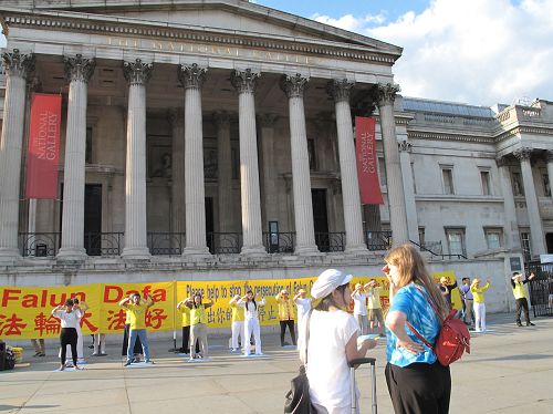 图4：二零一八年六月三日，在伦敦特拉法加广场，住在北英格兰、在星巴克公司工作的尼基•贝尔（右）向法轮功学员铭慧深入了解真相