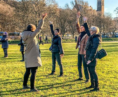 '图3：路人当场学炼法轮功，中间那位瑞典女孩临走时高兴地说：“这功法太神奇了，我一定要学！”'