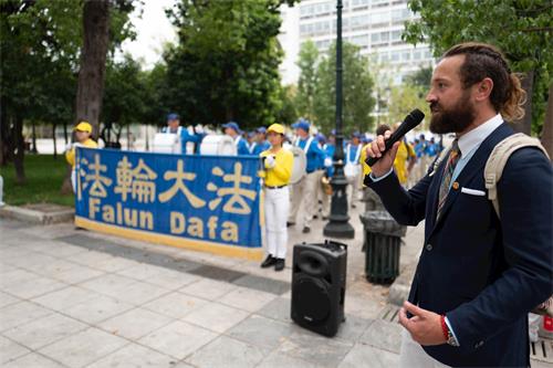 '图7：二零一九年十月十一日，法轮功学员代表在雅典宪法广场用希腊文和英文向民众介绍法轮功和欧洲天国乐团。'