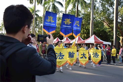 '图5～7：法轮大法社及天国乐团为下午游行压轴队伍，民众们纷纷拿起手机拍照留影。'