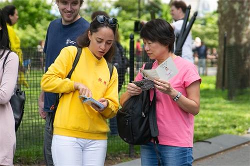 '图1～6：法轮功学员纽约炮台公园（Battery Park）拉起大型讲真相横幅，并向游客讲真相，人们驻足观看法轮功学员集体炼功'